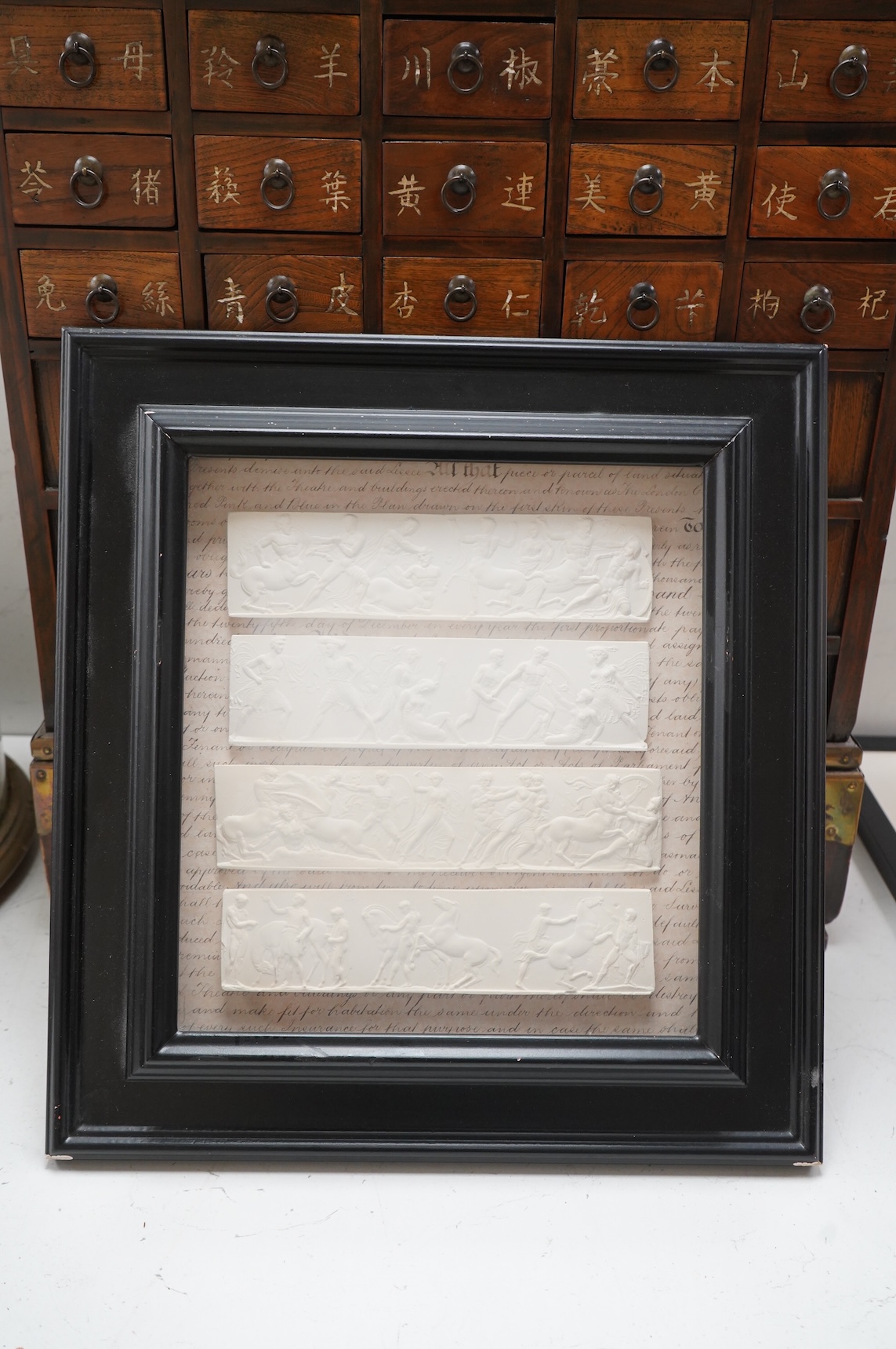 A set of four plaster plaques depicting classical scenes and four 18th/19th century architectural etchings, framed, largest 43cm high